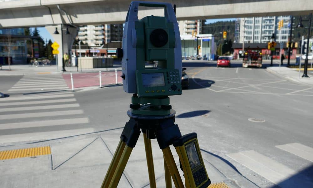 Surveying instrument set up on a city street for a boundary line survey before redevelopment