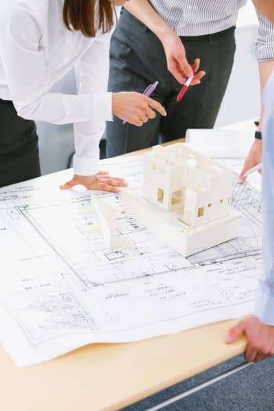 Engineers reviewing boundary line survey data and site plans for an upcoming construction project