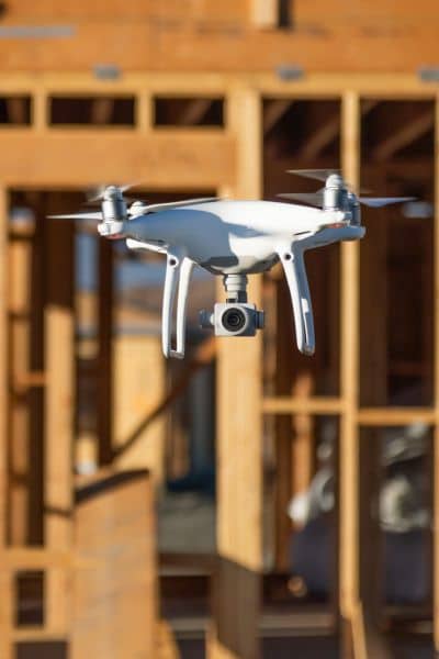 Drone capturing data at a construction site as part of modern construction survey safety practices