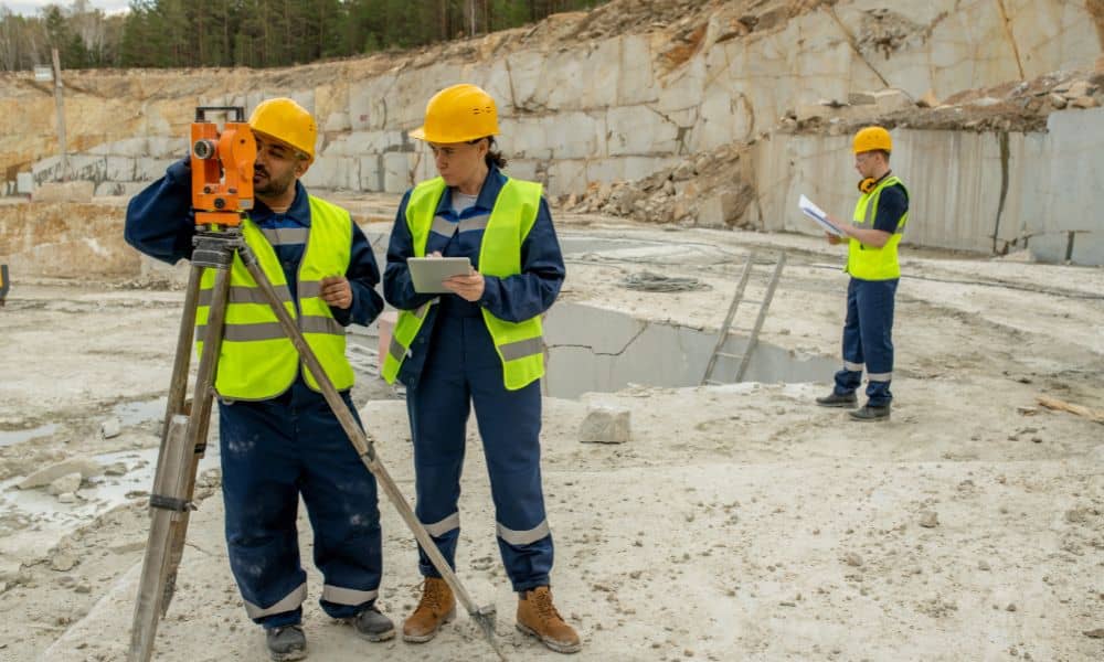 Surveyors using equipment at a construction site while performing a property survey during early project planning