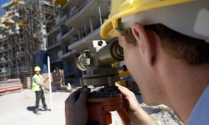 Surveyor verifying site control for an ALTA survey on a commercial construction project