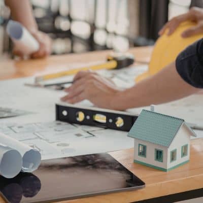 Commercial property plan review model - ALTA SURVEY Minneapolis Professionals reviewing building plans and a property model during due diligence, showing how an ALTA Survey helps assess risk in urban real estate transactions