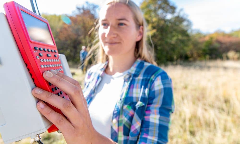 Surveyor using equipment in the field to perform a lot survey and measure property boundaries
