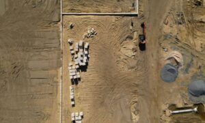 Aerial view of an active construction site with graded soil and equipment, a setting where LiDAR mapping can be used