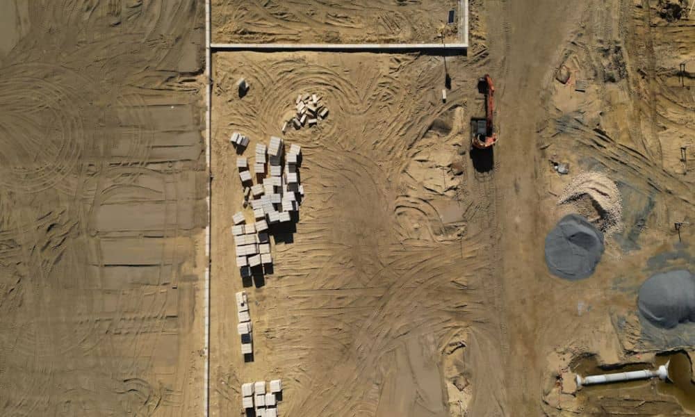 Aerial view of an active construction site with graded soil and equipment, a setting where LiDAR mapping can be used
